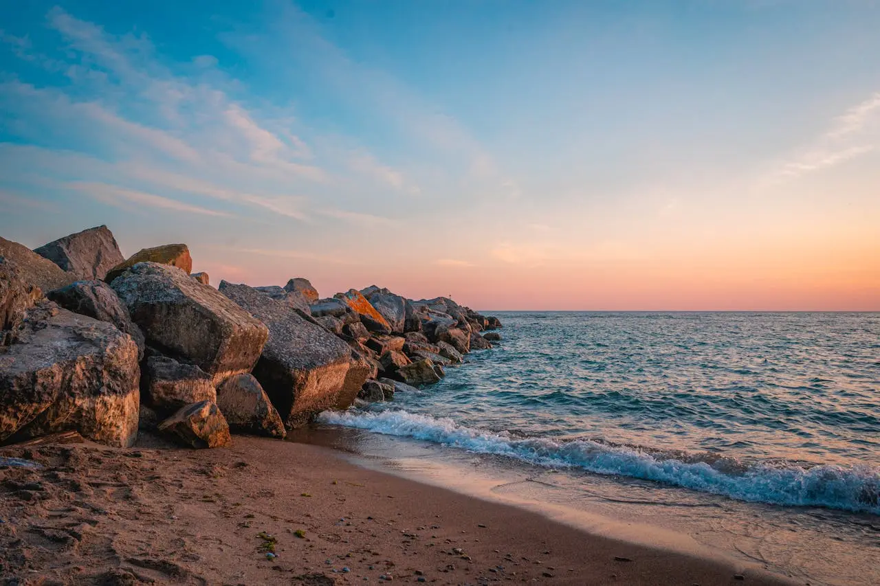 Ocean waves at golden hour — calm, rhythmic surf for a soothing ambience Wide view of ocean waves rolling onto a sandy beach at golden hour